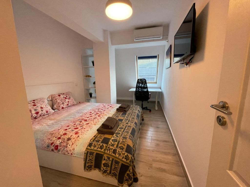 奥托佩尼Maramures Residence - Otopeni Airport and Therme - Self Check-in的一间卧室配有一张床和一台平面电视
