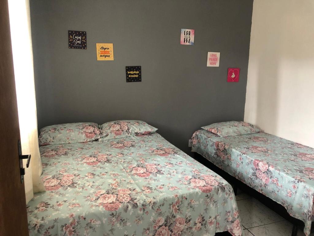 瓜鲁雅Kitnet do Costa Praia do Pereque Guaruja!!!的卧室内的两张床,墙上挂着海报