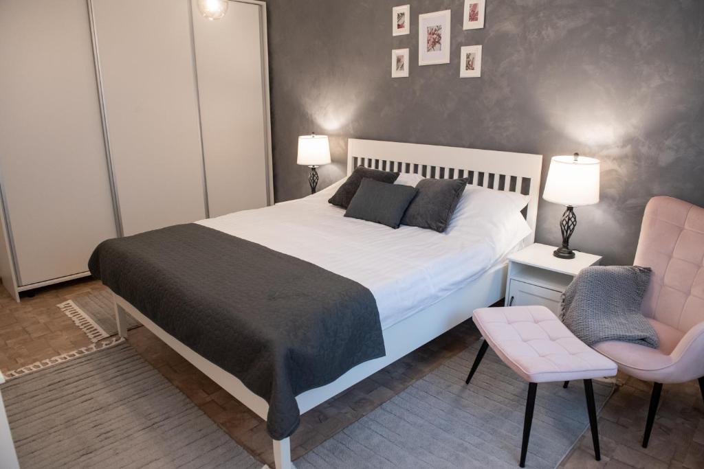 皮亚特拉-尼亚姆茨Urban Oasis的一间卧室配有一张大床和一张粉红色的椅子