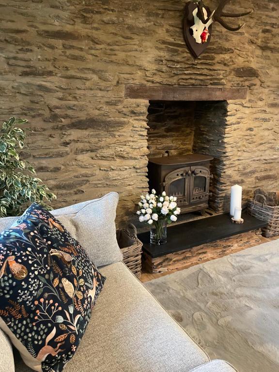 SimonsbathWinstitchen Cottage的带沙发和石制壁炉的客厅
