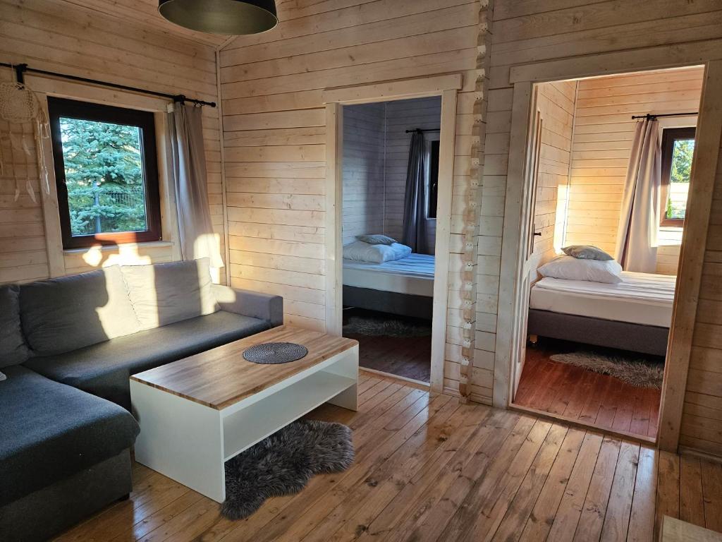 兹沃图夫Domek całoroczny MAGJAN z sauną的带沙发的客厅和带两张床的房间