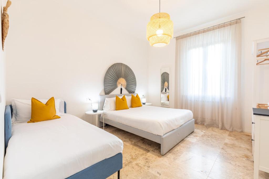 拉波拉诺泰尔梅L'Acqua e la Pietra的白色客房的两张床,配有黄色枕头