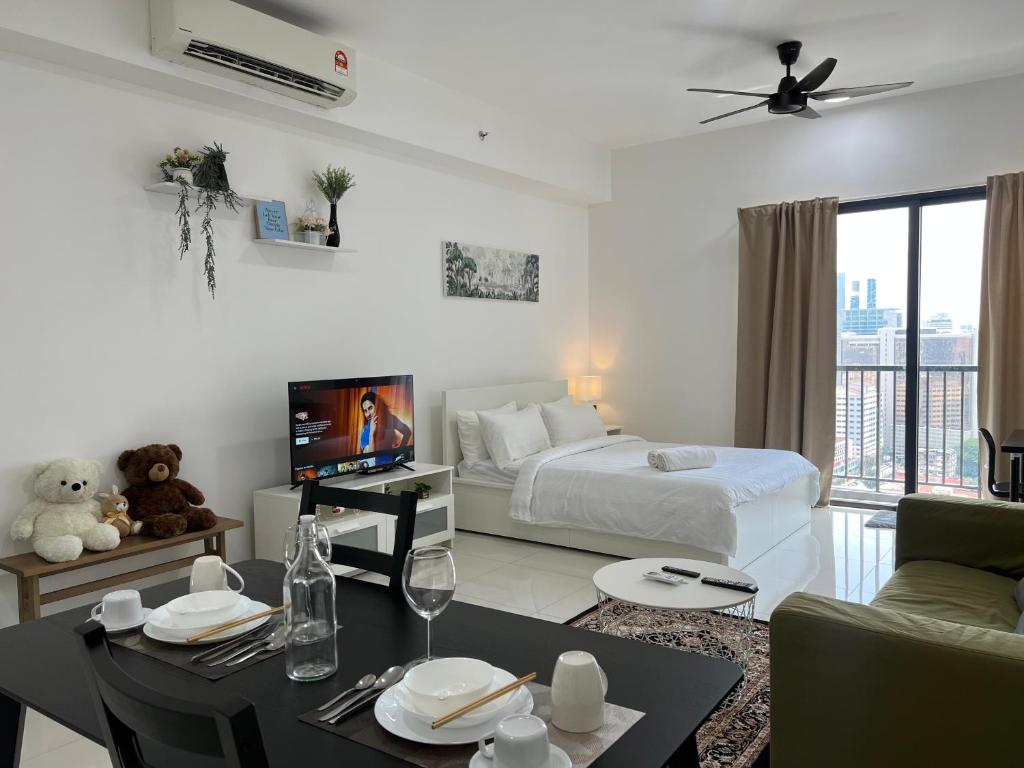吉隆坡Cozy luxury couple studio apartment chambers kl klcc kl tower view的白色的客房配有床、桌子和电视。