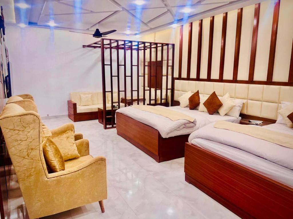 木尔坦The Signature Hotel Multan的酒店客房,配有两张床和椅子