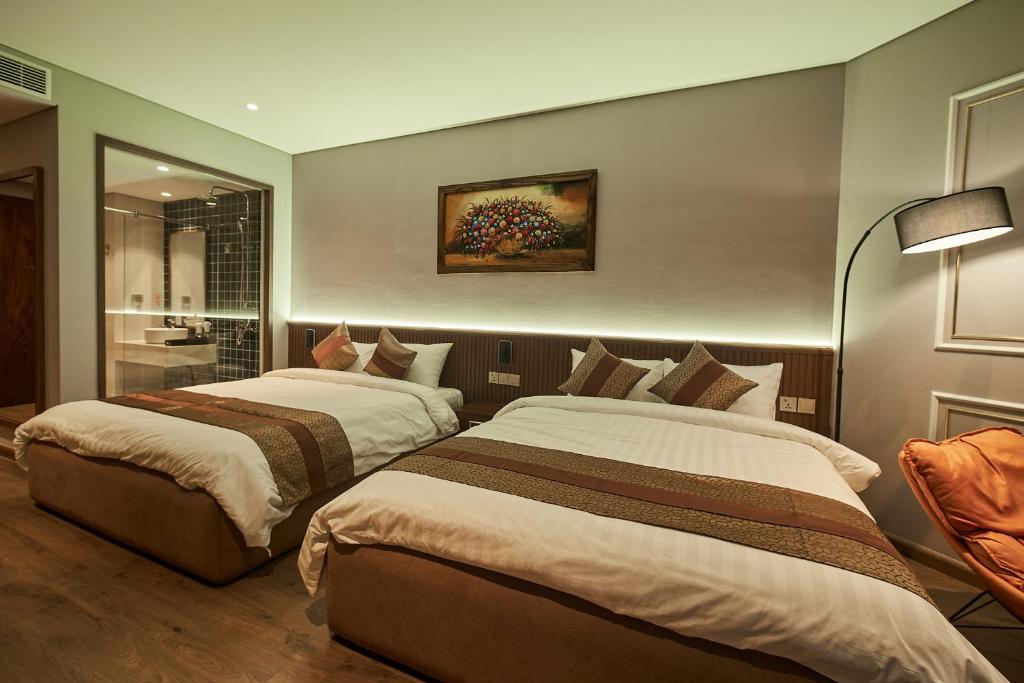 Ấp Long SơnApec Mandala Wyndham Mui Ne Ngoc Linh的配有2张床的酒店客房 - 带浴室
