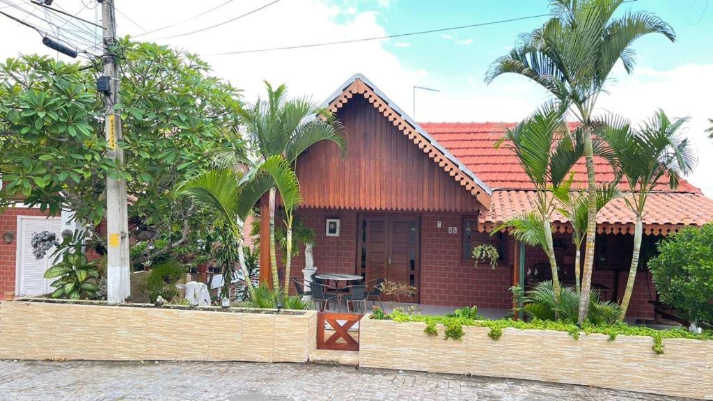格拉瓦塔Casa 7 no Condomínio Chácara Alpina- Rua Tabajara的前面有棕榈树的房子