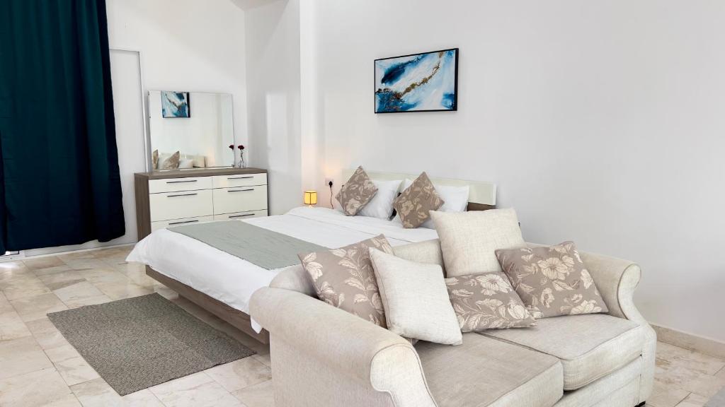 苏尔Wadi Shab Beach Villa的白色卧室配有床和沙发