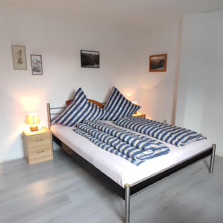 巴特哈尔茨堡Gästehaus Familie Rinke的一张带蓝色和白色枕头的床和床头柜