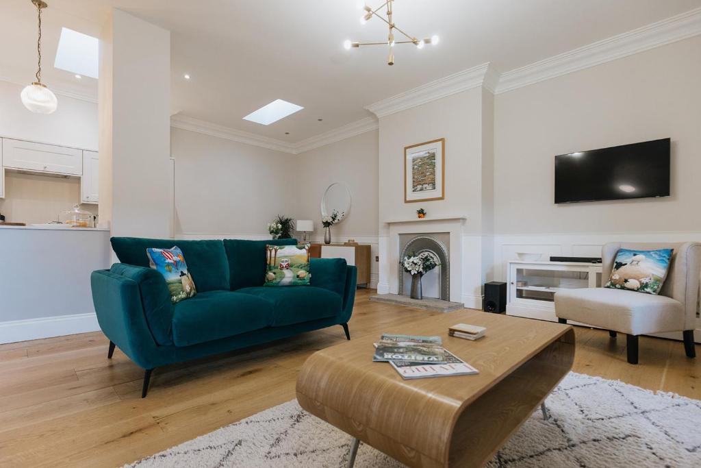 里士满SWALEDALE, OLD SCHOOL ROOMS - Luxury Apartment in Richmond, North Yorkshire的客厅配有蓝色的沙发和桌子