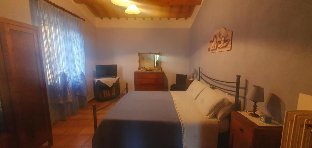 蒙特普齐亚诺乐奥格里诺迪玛提那公寓的一间卧室配有一张床、梳妆台和镜子