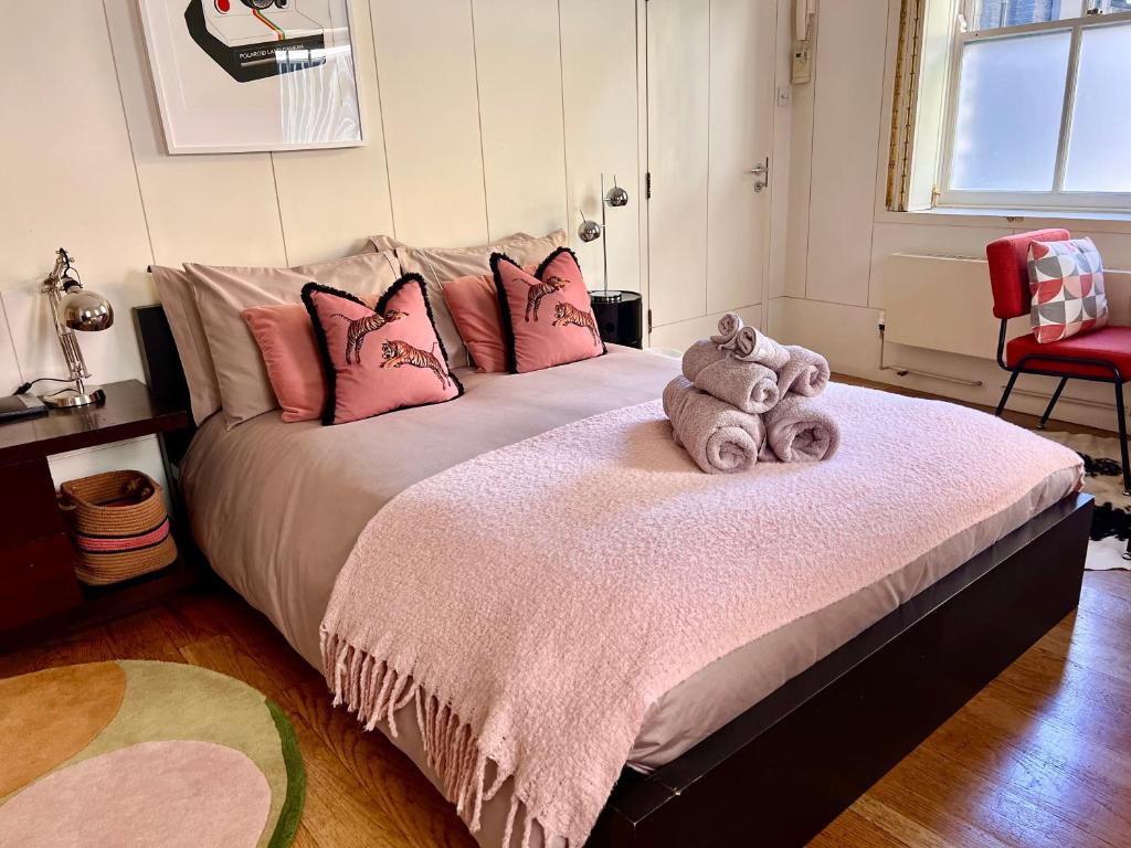 伦敦肖迪奇私人一室公寓的卧室配有一张带粉红色枕头的大床