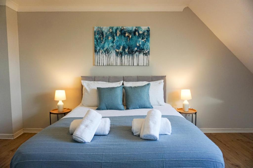 贝德福德Oak House - Spacious Townhouse, FREE gated parking, perfect for corporate, contractor & Leisure guests的一间卧室配有蓝色的床和3个枕头