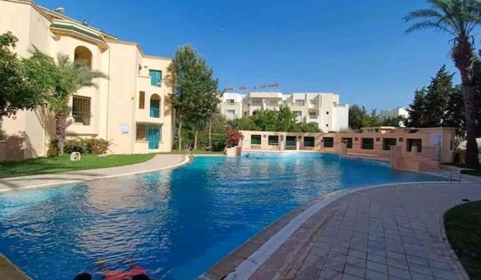 哈马马特Appartement résidence Port yasmine hammamet的大楼前的大型游泳池