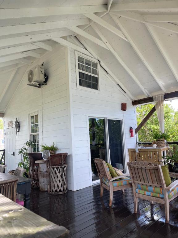 拿骚Hidden Paradise - Cottage的白色的房子,设有门廊和摇椅