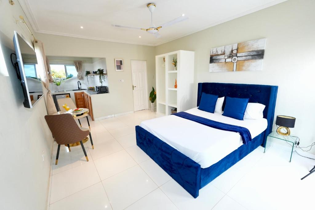 阿克拉Lukas Garden Accra的一间卧室配有一张蓝色的床和一张桌子