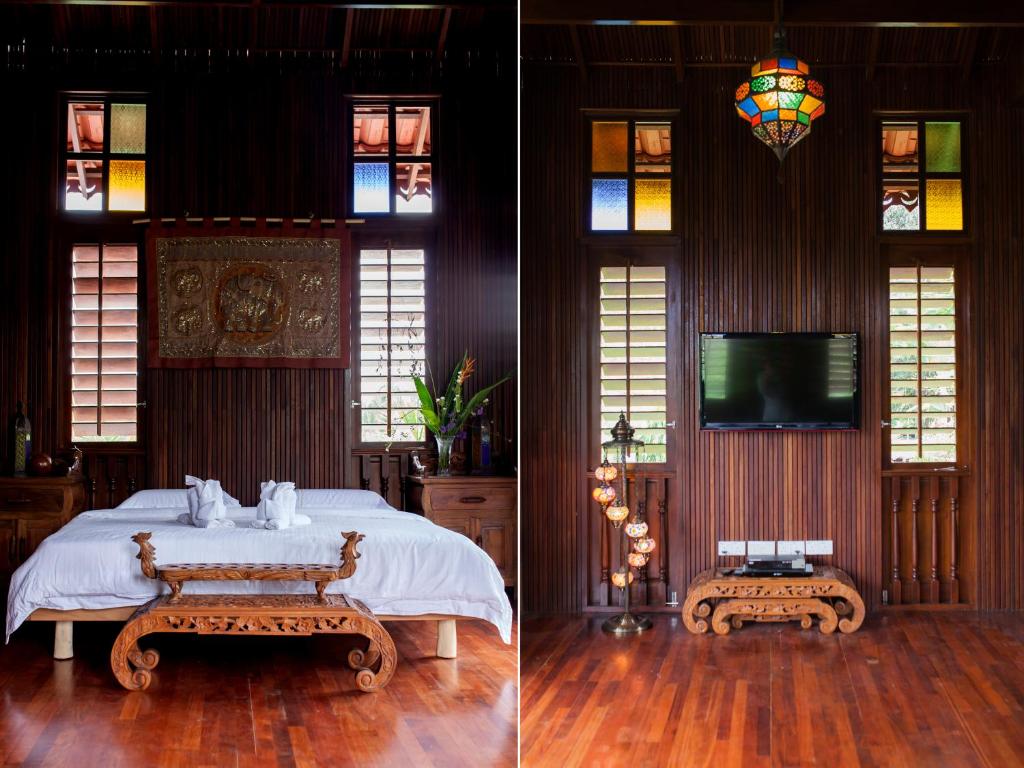 怡保Arundina的一间卧室设有一张床、一台电视和彩色玻璃窗。