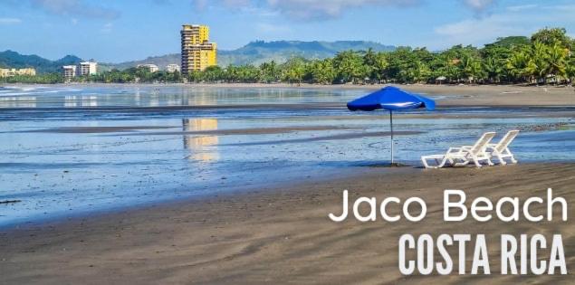 雅科Villas Paraíso Jacó B20的海滩上的两把椅子和一把遮阳伞