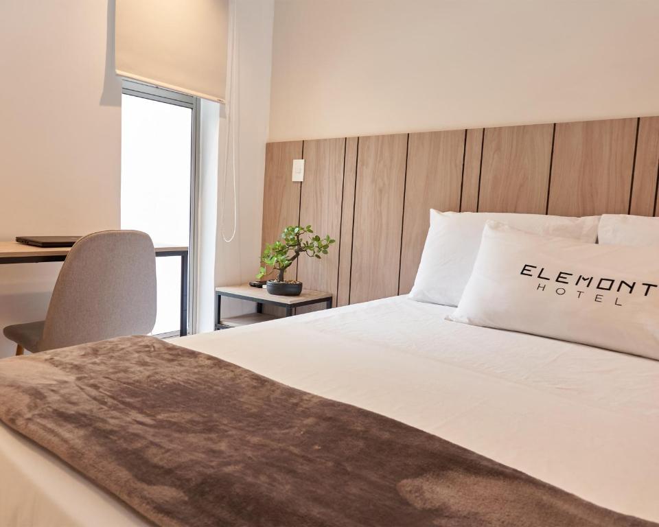 麦德林Elemont Hotel的一间卧室配有一张床和一张桌子及椅子