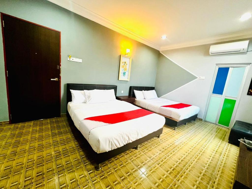 丰盛港DAILY INN HOTEL的一间酒店客房,设有两张床和一扇门