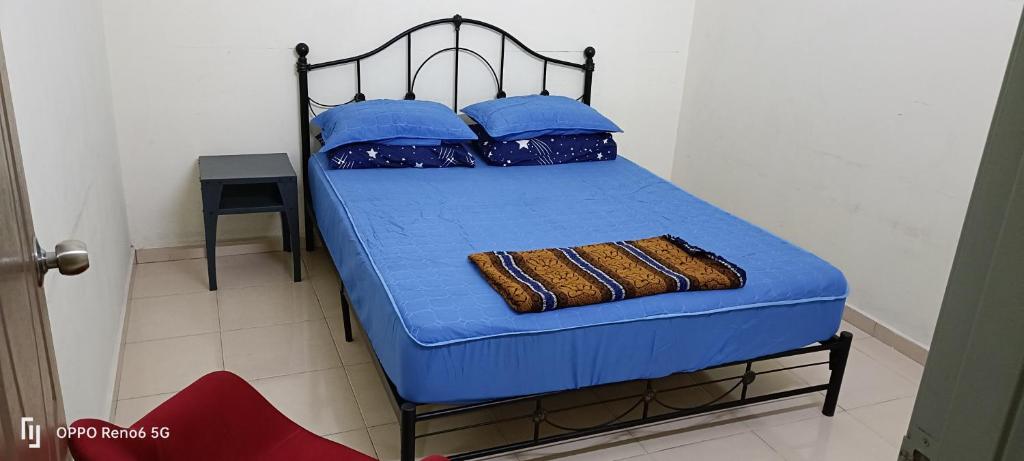 昔加末RW segamat homestay的一张带蓝色床单和蓝色枕头的床
