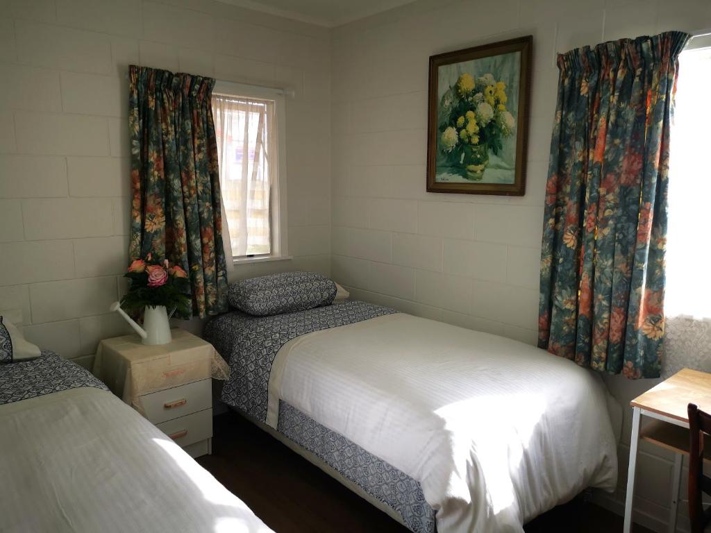 奥克兰Nice house on Wesley Auckland的一间卧室设有两张床和窗户。