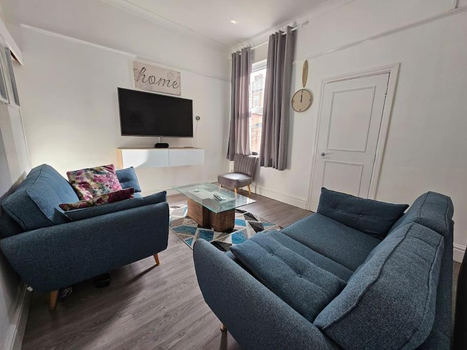 普雷斯顿Cheerful Home near Preston train station & Uclan的客厅配有2张蓝色沙发和电视