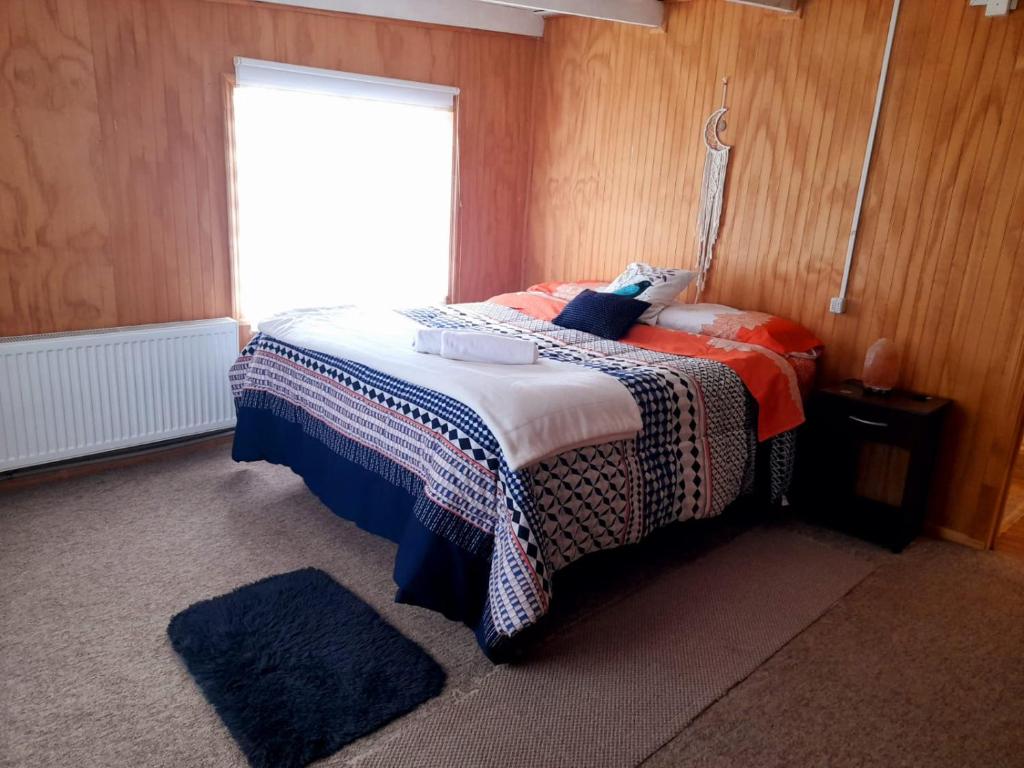 锡斯内斯港Arrayan The Cuyen的一间卧室配有蓝色和橙色枕头的床