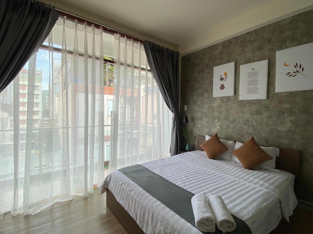 胡志明市Acorn Saigon Hotel - Bui Vien的一间卧室设有一张床和一个大窗户
