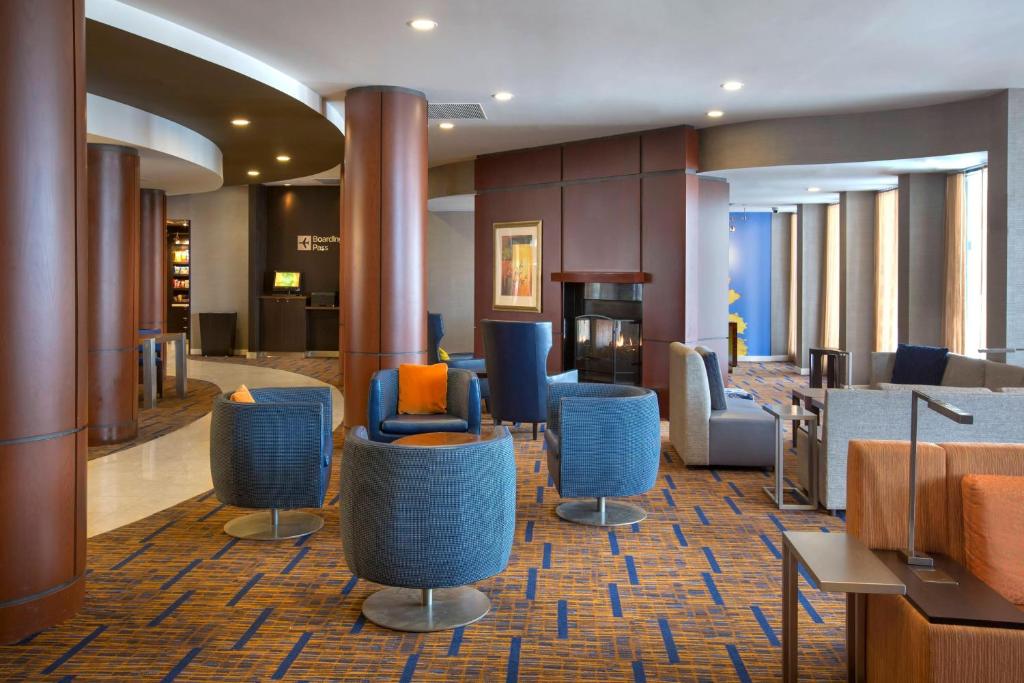 波士顿南波士顿万怡酒店的酒店大堂设有蓝色的椅子和桌子。
