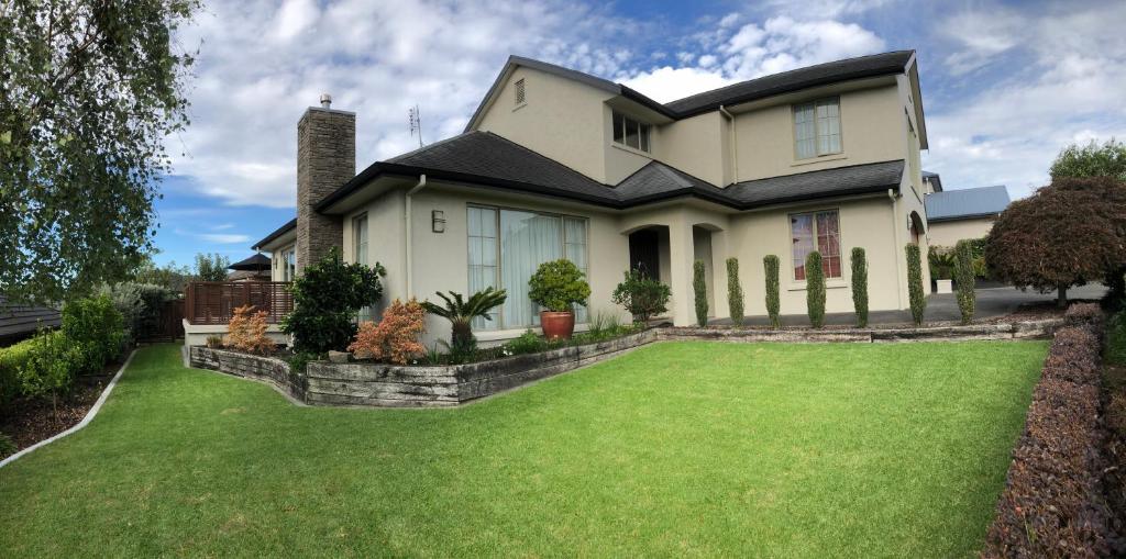 陶朗加Tauranga Homestead Retreat的前面有大草坪的房子