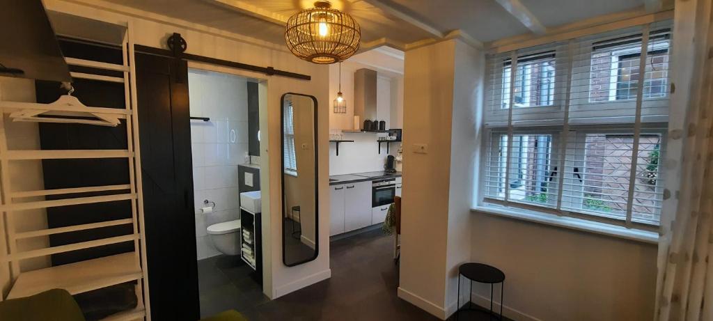 吕伐登Het prinsentuintje的客房设有厨房和带镜子的走廊