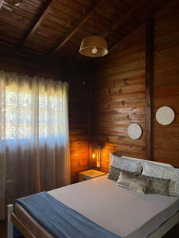 加罗帕巴CASA GAMBOA BEACH的木制客房内的一间卧室,配有一张床