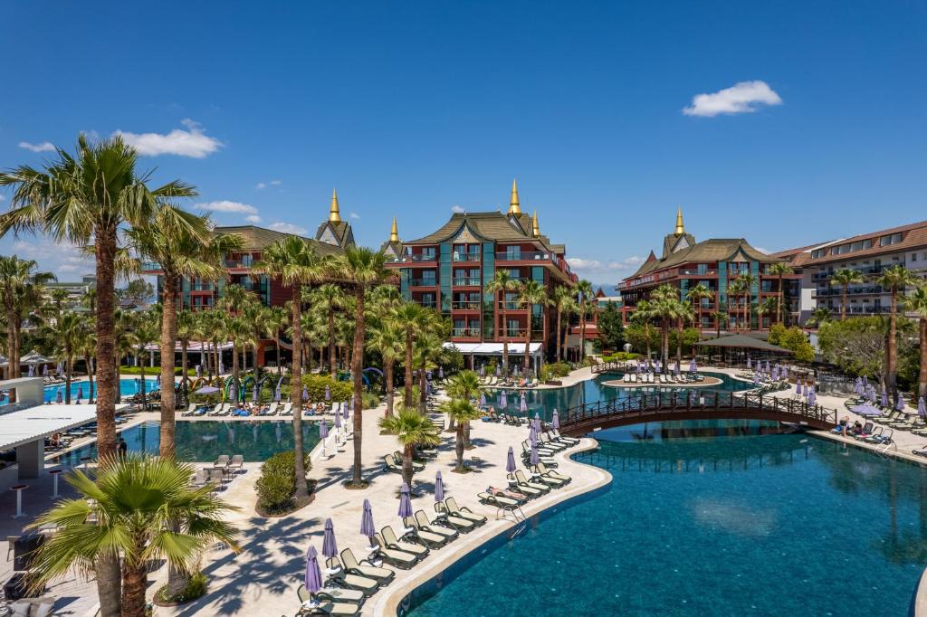 贝莱克暹罗典雅Spa酒店的一个带椅子和棕榈树的度假游泳池