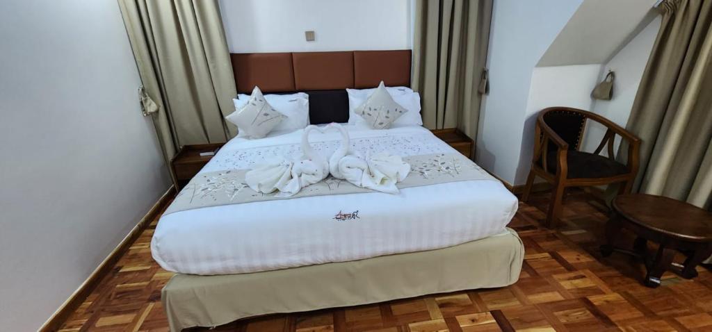 ShameneiAngani Resorts & Spa Limited的一间卧室配有一张带白色床单和一张桌子的床。