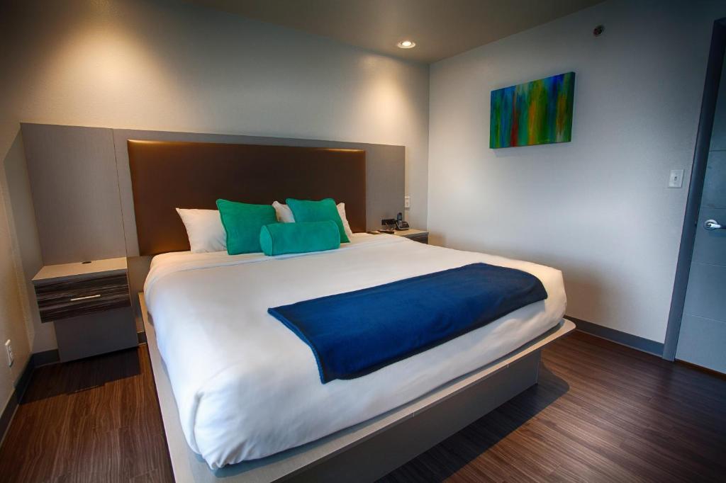 圣罗伯Z Loft Extended Stay Hotel的一间卧室配有一张带蓝色和绿色枕头的大床