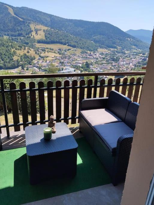 比桑Maison de montagne的阳台设有沙发和桌子,享有美景。
