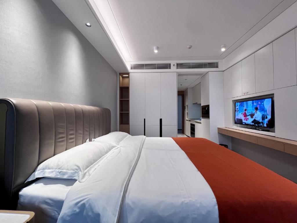 深圳凯森希悦酒店公寓(深圳国际会展中心店)的一间卧室配有一张大床和一台平面电视