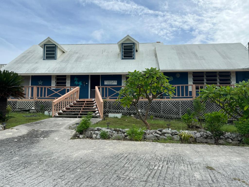 HermitageTurtles Nest Bahamas的蓝色的房子,前面有楼梯