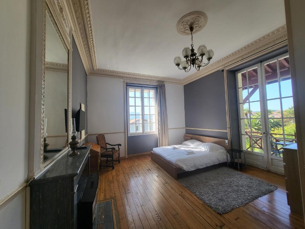 昂代贝尔维酒店的卧室配有一张床、一张书桌和窗户。