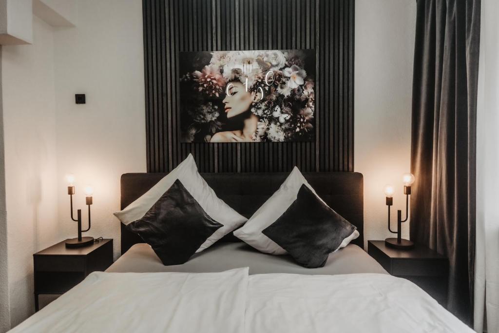 科隆Boutique Hotel Cologne的卧室配有一张床和一张女人的照片