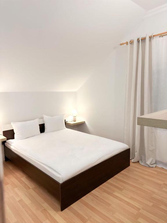 萨图马雷Hanul lui Ionut 2的一间卧室配有一张带白色床单的床和一扇窗户。