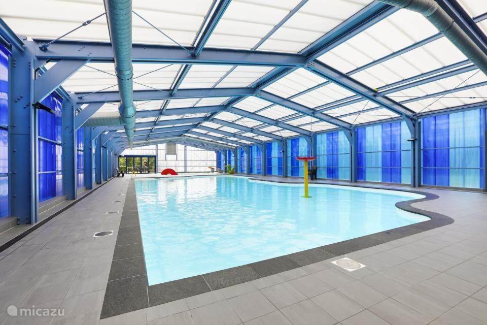 GramsbergenJuromi 42的大型室内游泳池拥有蓝色的墙壁和窗户