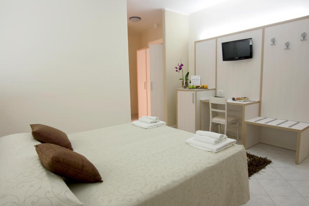 布林迪西尼莫酒店公寓的一间卧室配有一张带枕头的床和一张书桌