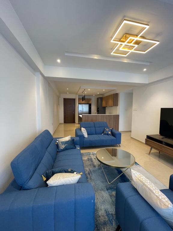 阿克拉Solaris Appartment 5&7th floor的客厅配有蓝色的沙发和桌子