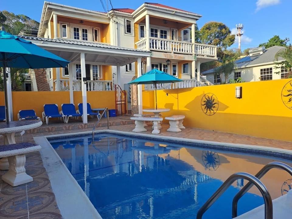 基督教堂市Villa Riana Barbados的一座带游泳池和黄色墙壁的房子