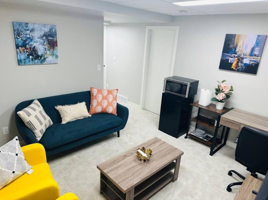 温尼伯1 Bedroom modern basement suite with private entrance的客厅配有蓝色的沙发和电视