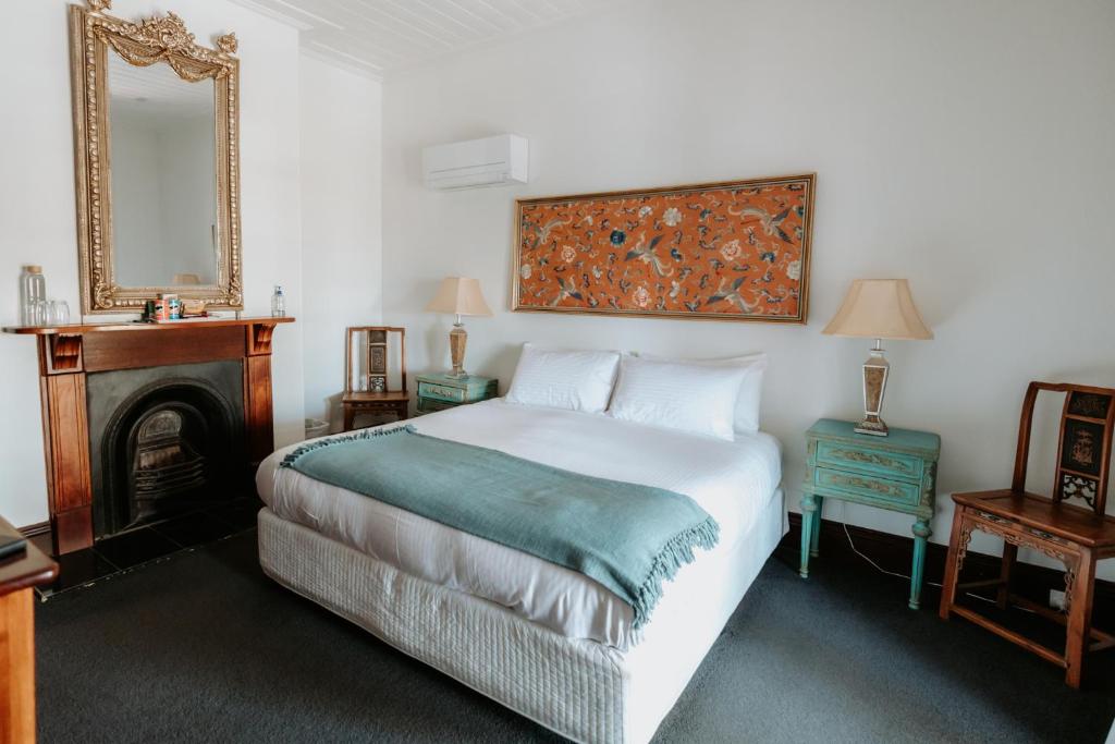 Morpeth勃朗特精品酒店 的一间卧室配有一张床、镜子和壁炉
