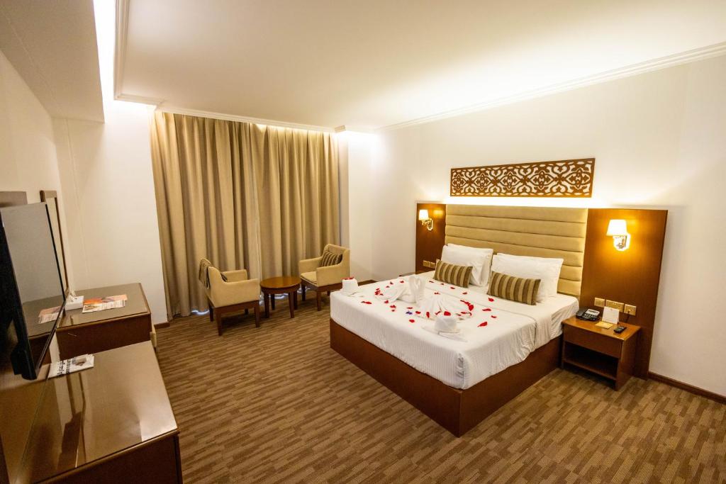 塞拉莱Hamdan Plaza Hotel Salalah, an HTG Hotel的酒店客房设有一张带玫瑰花的大床