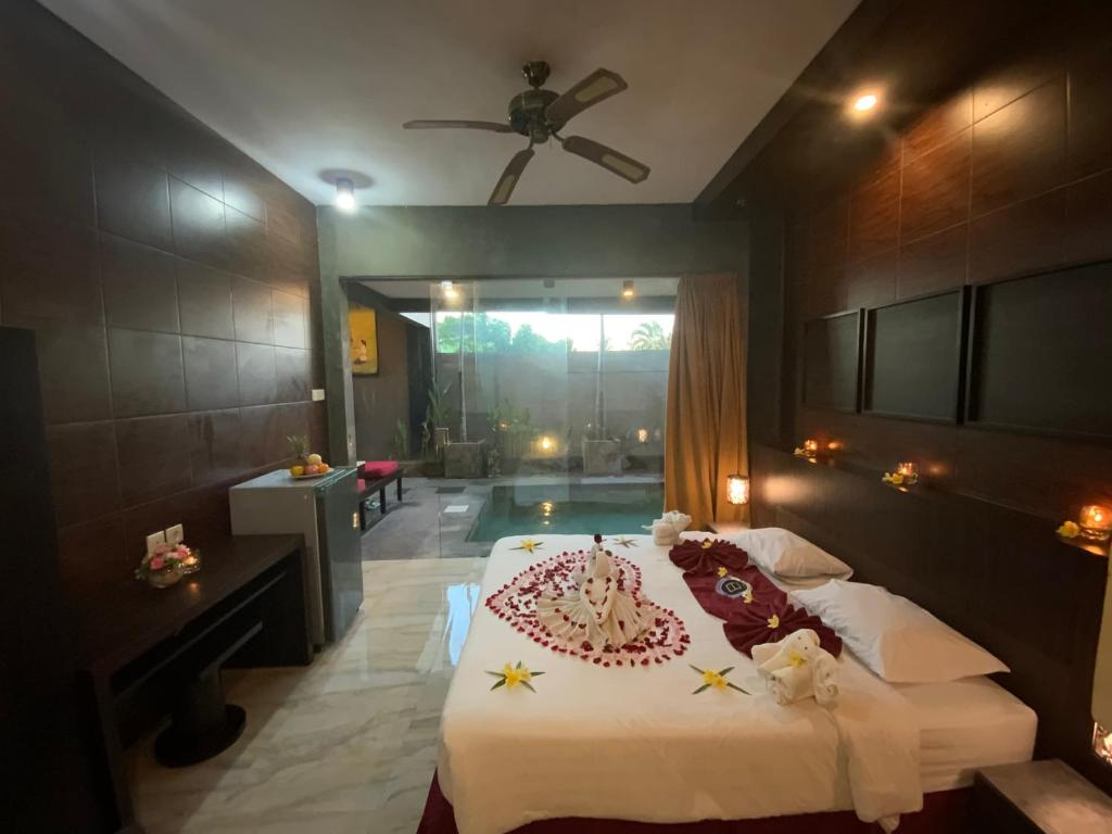 金巴兰巴厘岛金象精品别墅的一间卧室,配有一张床铺,上面有蛋糕