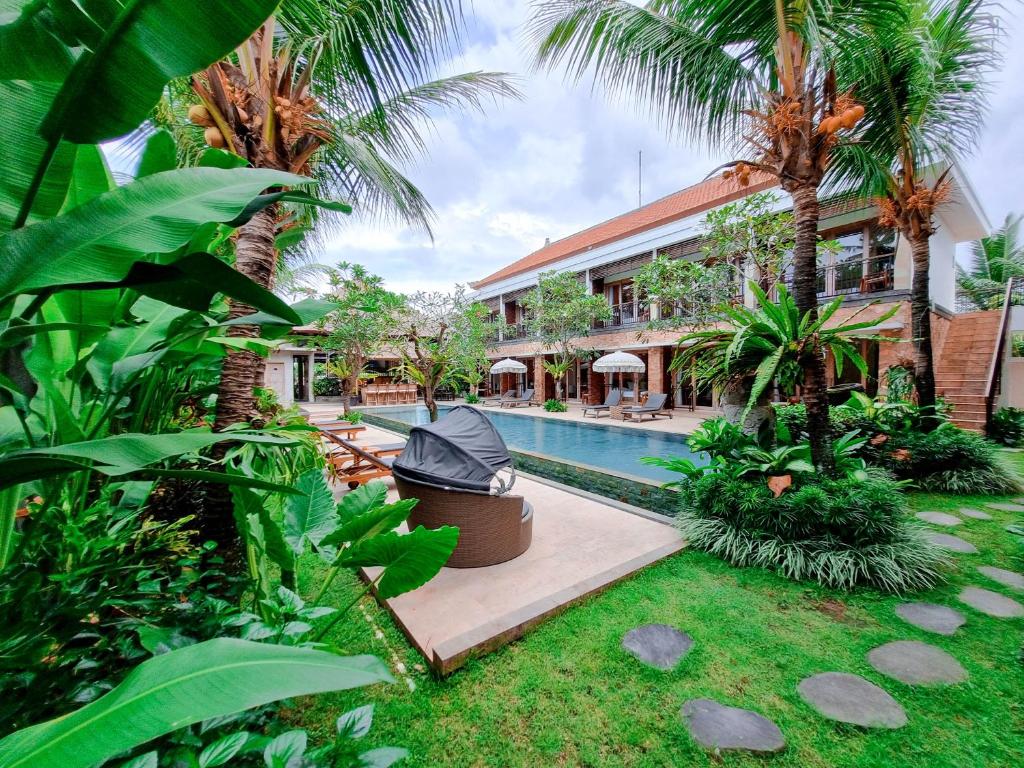 乌布Kahayana Suites Ubud的一个带游泳池和棕榈树的度假村